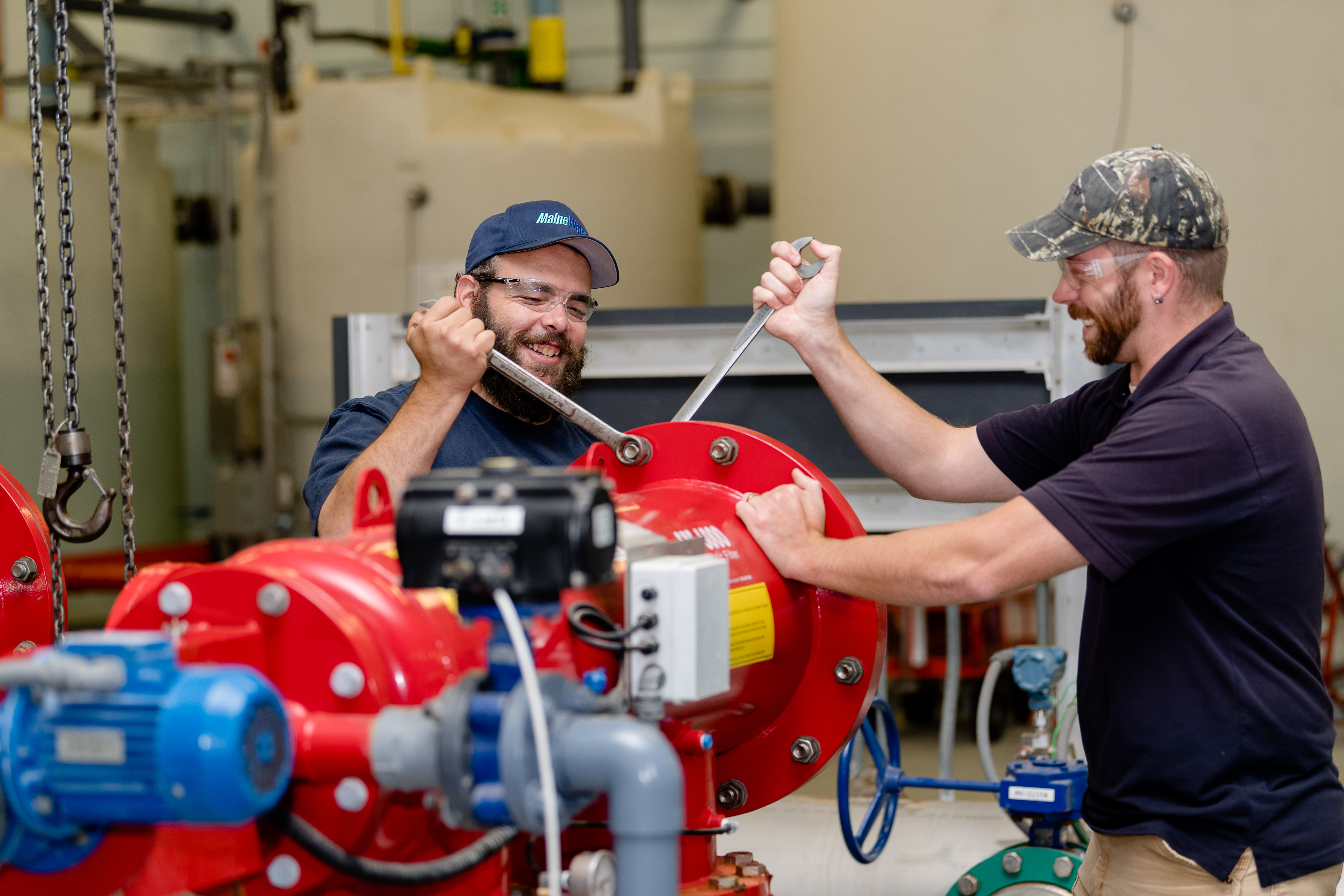 two Maine Water employees working a pipe